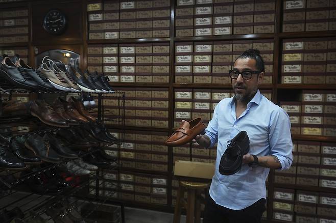 후안 호세 무글리아가 24일(현지시간) 아르헨티나 부에노스아이레스에 위치한 무글리아 매장에서 교황이 자주 신던 신발 모델(오른쪽)을 선보이고 있다. AP연합뉴스