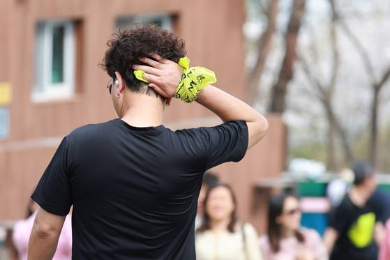 A citizen visiting N Seoul Tower, a landmark Seoul building with a transmission antenna sitting atop Namsan, is seen wiping away sweat as Seoul is seeing warm weather on April 17. [YONHAP]