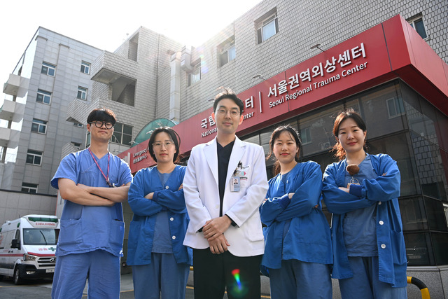 지난 3월 20일 서울 중구 국립중앙의료원 서울권역외상센터 앞에서 김영웅(가운데) 흉부외상 전담 전문의가 외상환자를 살리기 위해 동고동락하는 외상전담 간호사들과 함께 미소 지으며 서 있다.  문호남 기자