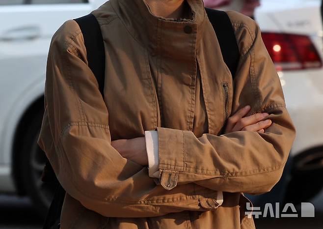 [서울=뉴시스] 이영환 기자 = 아침 기온이 떨어지며 비교적 쌀쌀한 날씨를 보인 25일 오전 서울 종로구 광화문네거리에서 외투를 걸친 시민이 신호를 기다리고 있다. 2025.04.25. 20hwan@newsis.com