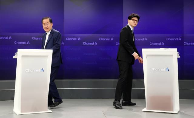 ▲25일 종로구 동아미디어센터 채널A스튜디오에서 국민의힘 대선 2차 경선 진출자인 한동훈, 홍준표 후보가 기념 촬영 후 자리로 돌아가고 있다. ⓒ연합뉴스