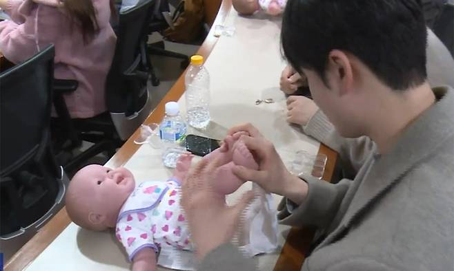 3일 경기 용인시 처인구의 용인예술과학대에서 열린 ‘휴머노이드 아기돌봄 체험’에서 한 남학생이 기저귀를 갈고 있다. 용인시 제공