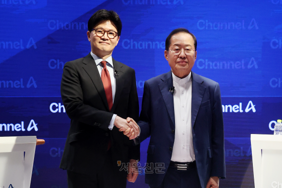국민의힘 대선 경선에 나선 한동훈(왼쪽) 후보와 홍준표 후보가 25일 서울 종로구 채널A 스튜디오에서 열린 국민의힘 대선 2차 경선 토론회에 앞서 악수하며 기념사진을 찍고 있다. 2025.4.25 국회사진기자단