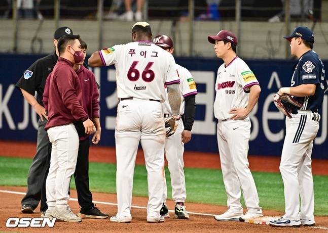 통증을 호소하는 푸이그(가운데)와 몸 상태를 체크하는 스태프들.