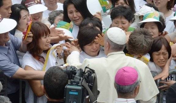 프란치스코 교황이 2014년 8월 15일 대전월드컵경기장에서 열린 ‘성모 승천 대축일 미사’에 참석하려고 이동하던 중 세월호 참사 유가족들을 위로하고 있다. 교황은 이날 미사에서 왼쪽 가슴에 노란색 세월호 추모 배지를 달고 “세월호 사건으로 생명을 잃은 모든 이를 성모님께 의탁한다”고 말했다.&nbsp;사진공동취재단