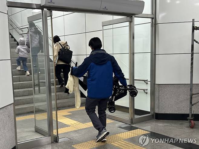 엘리베이터가 없어서 (서울=연합뉴스) 김유진 인턴기자 = 지난 7일 오후 서울 지하철 5호선 광화문역의 한 출구에서 한 남성이 유모차를 들고 계단을 오르려 하고 있다. 2025.4.25