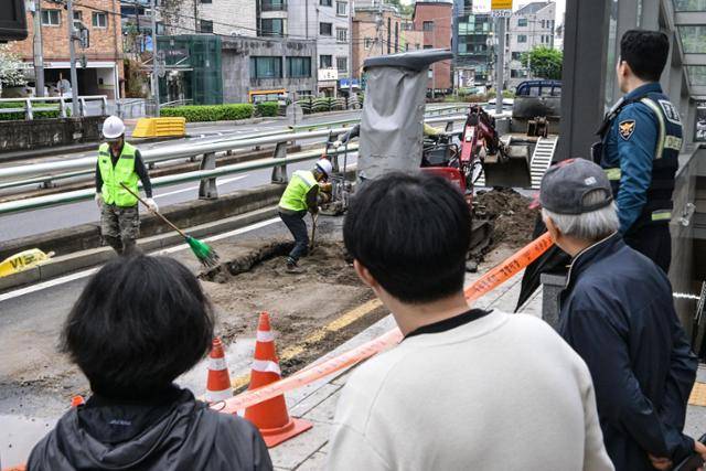 22일 서울 종로구 창신역 1번 출구 앞에 생긴 땅꺼짐으로 복구 작업이 이뤄지고 있다. 최주연 기자
