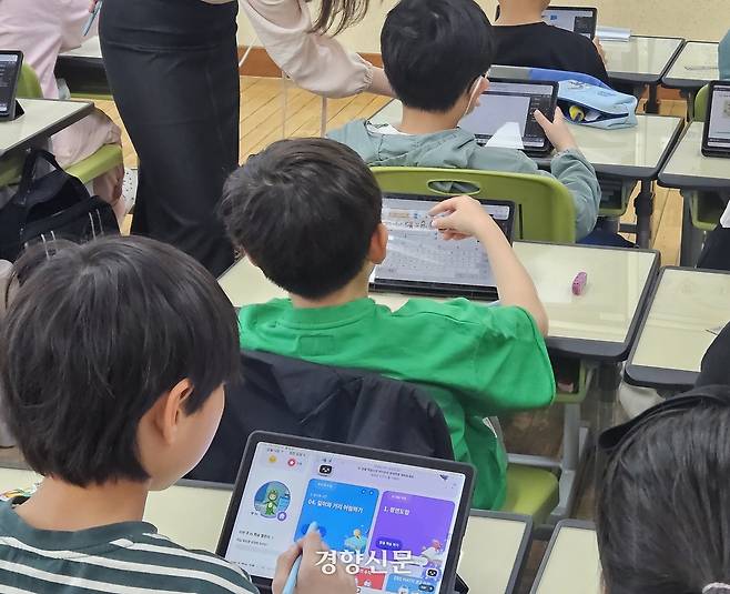 25일 경기도의 한 초등학교 3학년 학생들이 AI 디지털교과서를 활용한 수학 수업에 참여하고 있다. 이날 학생들은 화면 전환을 어려워해 교사에게 계속 도움을 요청했다. 사진은 교사 도움을 기다리는 세 학생의 태블릿PC에 각각 다른 화면이 띄워져 있는 모습. 김송이 기자