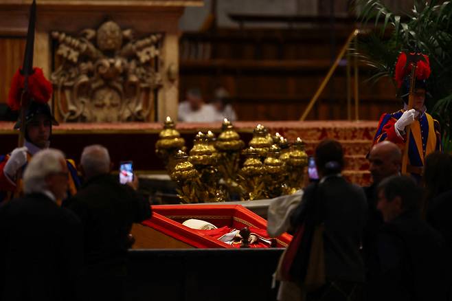 지난 23일(현지시간) 바티칸 성 베드로 대성당에 안치된 프란치스코 교황에게 조문객들이 경의를 표하고 있다. 로이터연합뉴스
