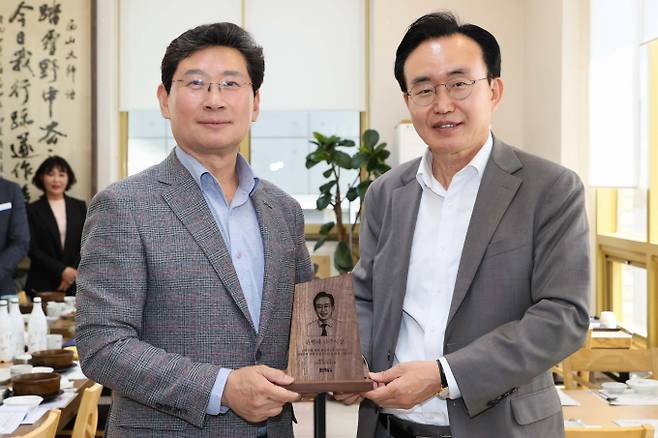 25일 나주를 방문한 이상일 용인특례시장(왼쪽)이 윤병태 나주시장에게 목재 기념패를 전달하고 있다. / 사진제공=용인특레시
