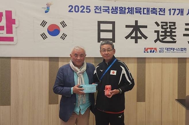 주원홍 대한테니스협회 회장과 일본의 토모자와 요시히로 감독이 환영연에서 우정의 선물을 교환한 뒤 포즈를 취하고 있다. 김경무 기자