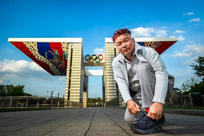 황영조 국민체육진흥공단 마라톤 감독이 서울 방이동 올림픽공원 세계 평화의 문 앞에서 운동화 끈을 고쳐 매고 있다. “마라톤은 가장 원초적이고 인간적인 운동입니다. 인간이니까 뛰어야죠!” /이건송 영상미디어 기자