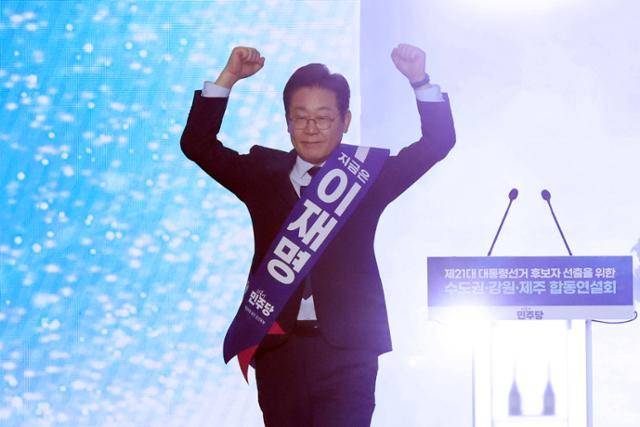 이재명 더불어민주당 전 대표가 27일 경기 고양시 킨텍스에서 열린 '제21대 대통령선거 후보자 선출을 위한 수도권·강원·제주 경선 및 최종 후보자 선출 대회'에서 정견 발표를 하기 위해 연단으로 나서며 두 팔을 들어 올리고 있다. 연합뉴스