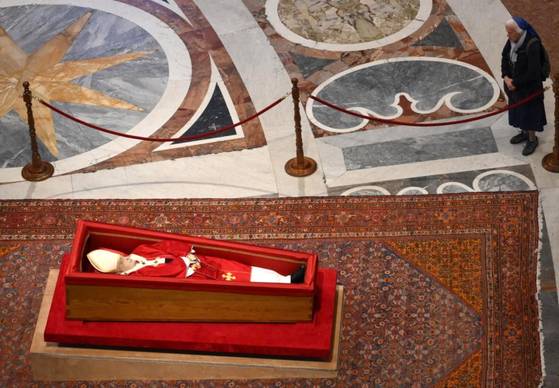 제느비에브 자넹그로스 수녀가 지난 23일(현지시간) 바티칸 성 베드로 대성전에 안치된 프란치스코 교황의 관 곁으로 다가가 조문하고 있다. AFP=연합뉴스