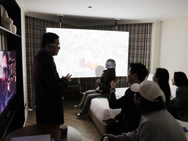 지난 24~26일 그랜드조선 부산에서 열린 ‘루프 랩 부산 페어’에서 관람객들이 객실 침대에 앉아 미디어아트 작품을 관람하고 있다.  루프 랩 부산 제공