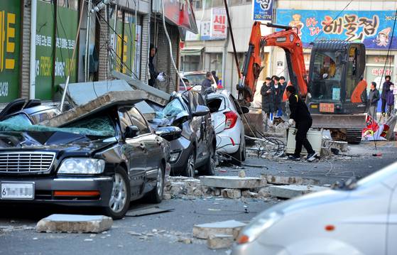 As a magnitude 5.4 earthquake strikes Pohang, North Gyeongsang, on Nov. 15, 2017, a building’s outer wall collapses onto parked cars along a roadside. [JOONGANG ILBO]