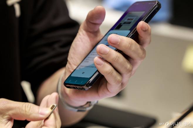 SK텔레콤은 최근 발생한 가입자 유심 정보 유출 사고와 관련해 유심 무료 교체를 실시한다. 사진은 지난 25일 서울시내 SK텔레콤 매장인 T월드를 찾은 고객이 유심 카드를 교체하는 모습. /사진=뉴시스