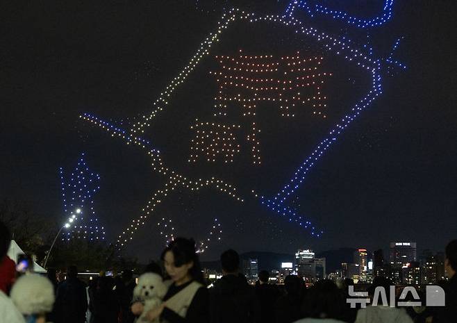 [서울=뉴시스] 김명년 기자 = 27일 오후 서울 광진구 뚝섬한강공원 수변무대에서 2025 한강 불빛 공연(드론 라이트 쇼)이 펼쳐지고 있다. 2025.04.27. kmn@newsis.com