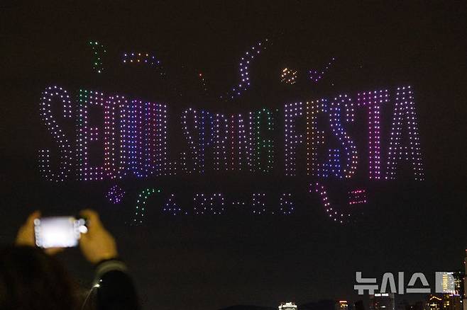 [서울=뉴시스] 김명년 기자 = 27일 오후 서울 광진구 뚝섬한강공원 수변무대에서 2025 한강 불빛 공연(드론 라이트 쇼)이 펼쳐지고 있다. 2025.04.27. kmn@newsis.com