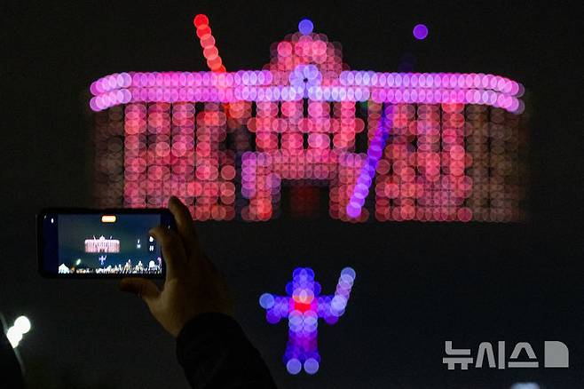 [서울=뉴시스] 김명년 기자 = 27일 오후 서울 광진구 뚝섬한강공원 수변무대에서 2025 한강 불빛 공연(드론 라이트 쇼)이 펼쳐지고 있다. 2025.04.27. kmn@newsis.com