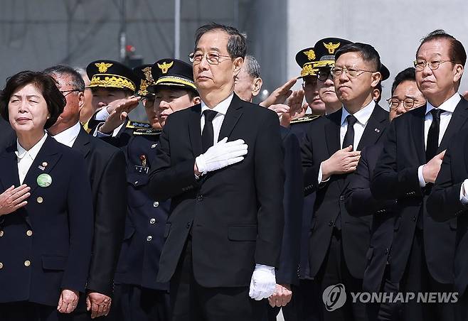 한덕수 권한대행, 순직의무군경의 날 기념식 참석 (대전=연합뉴스) 홍해인 기자 = 한덕수 대통령 권한대행 국무총리가 25일 국립대전현충원에서 열린 '2회 순직의무군경의 날 기념식'에서 참석자들과 참배를 마치고 자리로 돌아오며 국기에 경례하고 있다. 2025.4.25 hihong@yna.co.kr