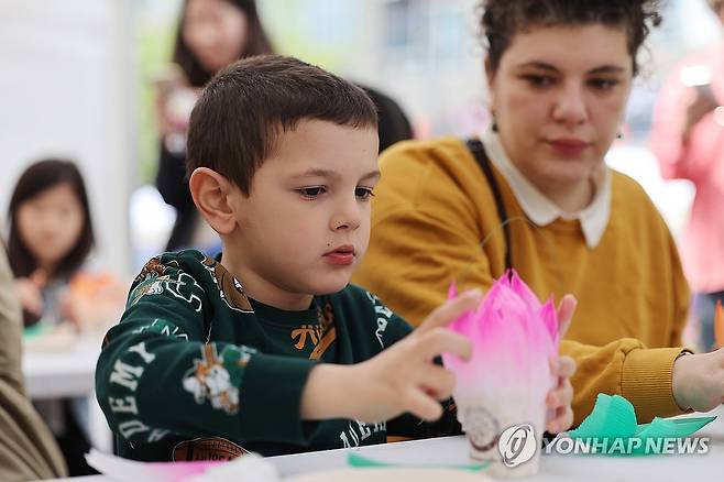 외국인도 즐기는 전통문화마당 (서울=연합뉴스) 임화영 기자 = 27일 서울 종로구 조계사 인근에서 열린 '2025 연등회 전통문화마당'을 찾은 외국인들이 연꽃등을 만들고 있다. 2025.4.27 hwayoung7@yna.co.kr