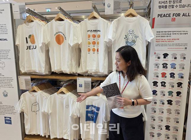 서귀포점 매장 직원이 제주 로컬 브랜드와 협업한 UTme!(유티미) 티셔츠를 소개하고 있다. (사진=한전진 기자)