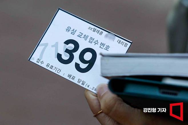 28일 서울 마포구 한 SK텔레콤 공식 인증 대리점을 찾은 고객들이 유심을 교체하기 위해 기다리며 직원에게 번호표를 받고 있다. SK텔레콤은 오늘부터 가입자들에게 유심 무료 교체서비스를 제공할 예정이다. 2025.4.28. 강진형 기자