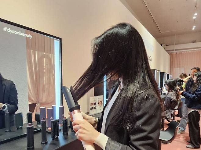 28일 오전 서울시 성동구 복합문화공간 'XYZ 서울'에서 열린 다이슨 신제품 공개 행사에서 기자가 '에어랩 코안다2x(투엑스) 멀티 스타일러 앤 드라이어'를 체험해보고 있다. 사진 박준이 기자