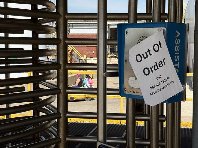 미국 인디애나주 코코모의 자동차 기업 스텔란티스 공장 출입문 인터폰에 '고장' 안내문이 반쯤 떨어진 채 붙어 있다. 출입구 안으로 노동자들이 이동식 카트를 타고 있는 모습. /박국희 특파원