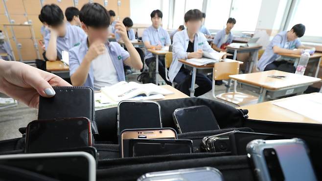 지난 2023년 9월 1일 대전의 한 고등학교에서 교사가 수업에 앞서 학생들의 휴대전화를 수거하고 있다. 당시 교육부가 ‘교원의 생활지도에 관한 고시’를 시행하면서 학생이 수업 중 휴대전화를 사용하는 행위를 금지했으나 휴대전화 수거가 ‘인권 침해’ 아니냐는 논란은 계속됐다./뉴스1
