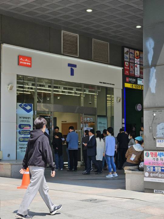 28일 오후 1시 SK텔레콤 T월드 서울 광화문점 앞에 유심을 교체받기 위해 찾아온 가입자들이 길게 줄을 서 있다. 김나인 기자