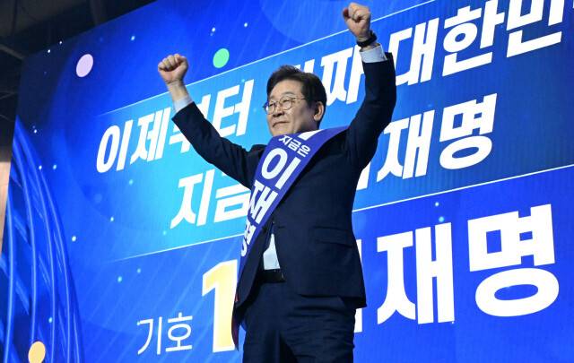 이재명 더불어민주당 대선 후보가 27일 수도권·강원·제주 합동연설회에서 손을 들어 인사하고 있다. 공동취재사진