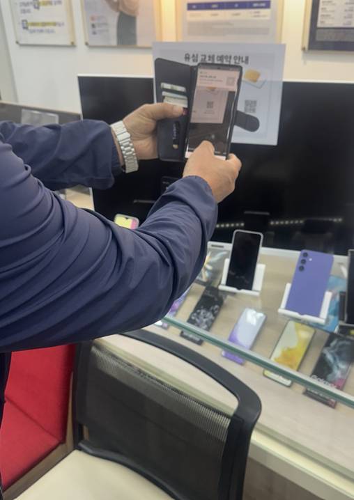 28일 오후 7시21분께 인천시 연수구의 한 SK텔레콤 공식 인증 대리점에 방문한 한 고객이 유심 재고가 없다는 매장 직원 말을 듣고 "회사가 문제나 만들지 말지"라며 호통을 친 뒤 마지못해 QR코드로 교체 예약을 하고 있다. [사진=조정훈기자]