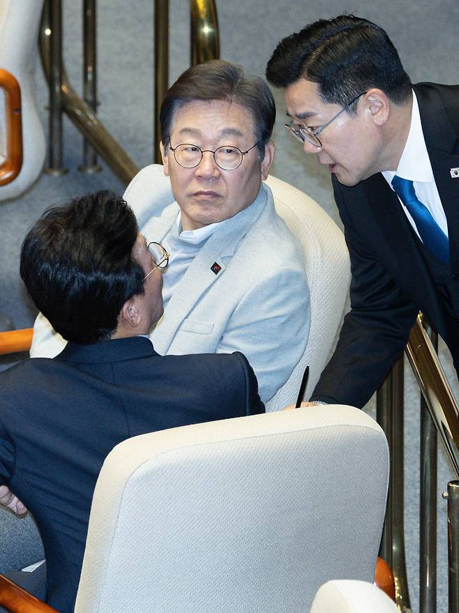 이재명 더불어민주당 전 대표가 지난 14일 정치·외교·통일·안보 분야 대정부질문이 진행된 국회 본회의에 참석해 있다. 앞쪽은 대화하는 박찬대 당대표 직무대행 겸 원내대표와 김민석 최고위원. 연합뉴스