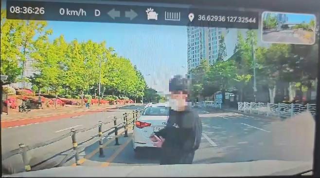 충북 청주의 한 고등학교에서 흉기 난동을 벌인 A군이 28일 도주 도중 B씨의 차량에 접근하는 모습이 담긴 블랙박스 화면. A군은 아이들이 탄 차량 뒷좌석 창문을 노크했다가 B씨가 운전석 문을 열자 흉기로 B씨의 얼굴을 찌른 뒤 도주했다. B씨 제공