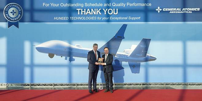 김병권 휴니드 해외사업총괄(오른쪽)과 찰스 맥비커 GA-ASI 부사장이 시상식에서 기념촬영을 하고 있다. [사진 제공=휴니드]