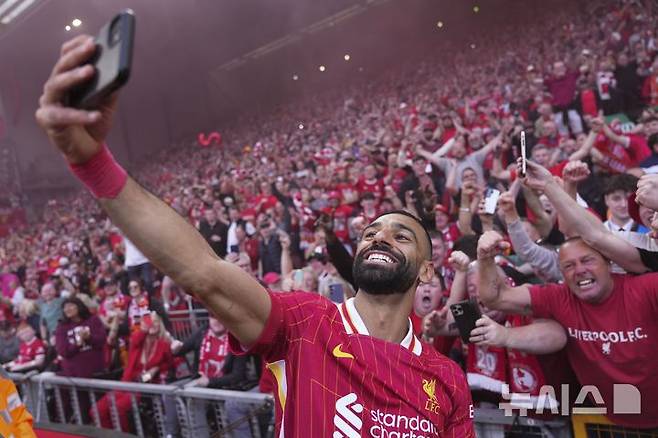 [리버풀=AP/뉴시스] 리버풀의 모하메드 살라가 27일(현지 시간) 영국 리버풀의 안필드에서 열린 2024-25 프리미어리그 34라운드 토트넘 홋스퍼와의 경기에서 승리해 리그 우승을 확정한 후 팬들과 셀카를 찍으며 기뻐하고 있다. 리버풀은 손흥민이 부상으로 빠진 토트넘에 5-1로 승리하고 남은 경기 결과에 상관없이 우승을 확정했다. 2025.04.28.