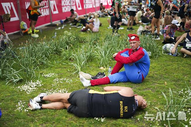 [런던=AP/뉴시스] 27일(현지 시간) 영국 런던에서 열린 2025 런던 마라톤에 참가한 참가자들이 완주 후 세인트 제임스 공원에서 휴식하고 있다. 2025.04.28.