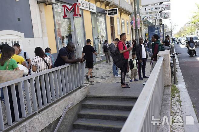 [AP/뉴시스] 대규모 정전 사태가 이베리아 반도에 발생한 28일 낮 포르투갈 수도 리스본에서 지하철이 운행 중지된 가운데 시민들이 핸드폰을 체크하고 있다