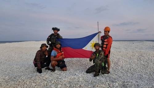 남중국해 암초서 국기 펼친 필리핀 군인들 [서필리핀해 국가 태스크포스 관계자 엑스(X·옛 트위터) 캡처. 연합뉴스 제공]