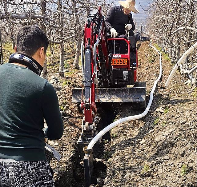 12일 경남 밀양시 산내면 과수원에서 굴착기를 활용해 ‘무굴착 땅속배수 기술’을 시공하는 모습. 경남도농업기술원