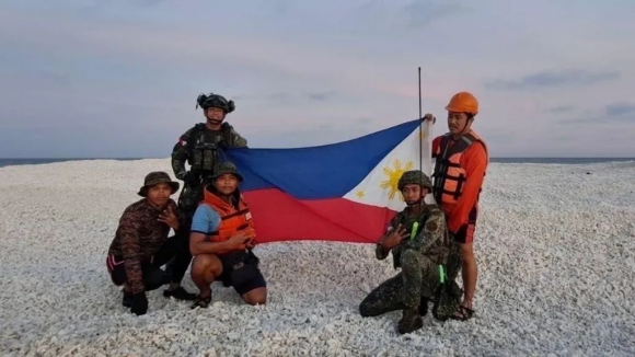 중국 해경의 인공기 게양 이후 필리핀 경찰이 남중국해 모래톱에서 똑같은 자세로 국기 게양 사진을 찍었다.