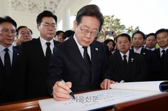 이재명 더불어민주당 대선 후보가 28일 오전 서울 동작구 국립서울현충원 현충탑에 참배를 마친 뒤 방명록을 적고 있다. 2025.4.28 안주영 전문기자