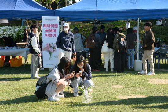 지난 28일부터 이틀간 경상국립대 가좌캠퍼스 중앙도서관 옆 잔디광장에서 진행된 '창업동아리 체험활동 전시회'에서 학생들이 체험활동을 만든 작품을 바닥에 놓고 사진을 찍고 있다.