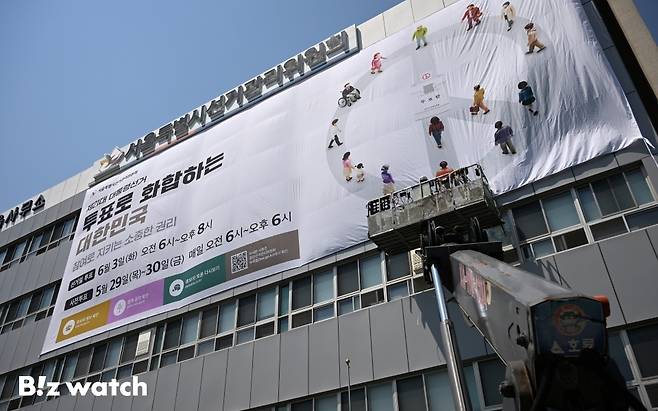 29일 오후 서울 종로구 창경궁로 서울시선거관리위원회 외벽에 관계자들이 제21대 대통령 선거 대형 홍보 현수막을 게시하고 있다./사진=이명근 기자 qwe123@