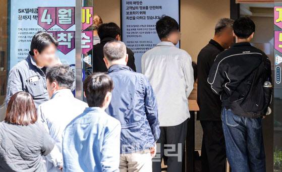 해킹 공격으로 가입자 유심 정보가 탈취된 SK텔레콤이 가입자 유심 무상 교체를 시작한 28일 서울 마포구의 한 T월드 본사 직영 대리점을 찾은 고객들이 유심을 교체하기 위해 대기하고 있다.