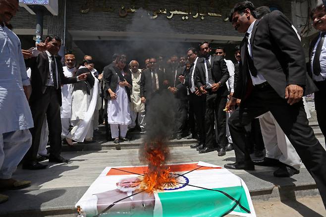 28일(현지시간) 파키스탄 서부 도시 물탄에서 열린 반인도 시위에서 인도 국기와 나렌드라 모디 인도 총리의 사진이 담긴 현수막을 불태우고 있다. (사진=AFP)