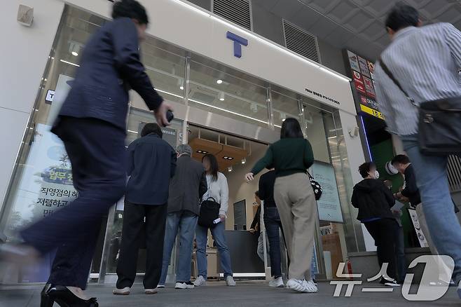 해킹 공격으로 가입자 유심 정보가 탈취된 SK텔레콤이 가입자 유심 무상 교체를 시작한 28일 오전 서울 종로구 T월드 매장 앞에서 고객들이 온라인 예약을 안내 받고 있다. 2025.4.28/뉴스1 ⓒ News1 박정호 기자