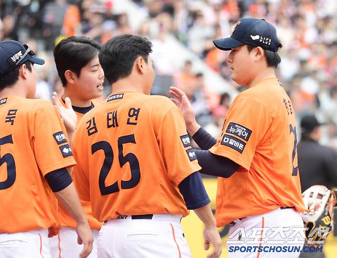 투구를 마치고 동료들과 하이파이브를 나누는 한승혁.